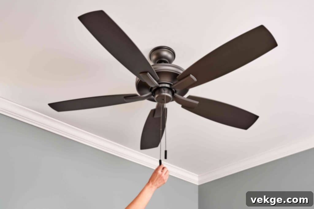 A ceiling fan with blades turning counter-clockwise, creating a cooling downdraft