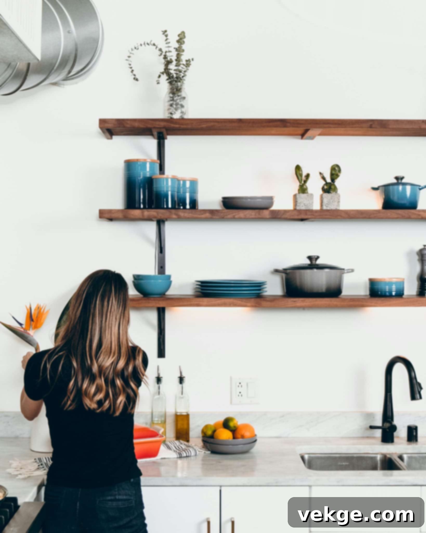A person meticulously arranging decor on a shelf, demonstrating attention to detail in home decorating.
