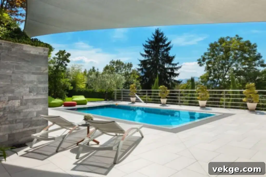 How to Make a Pool Visually Appealing With Aesthetics? A semi-inground pool with decorative stone coping and lush green landscaping.