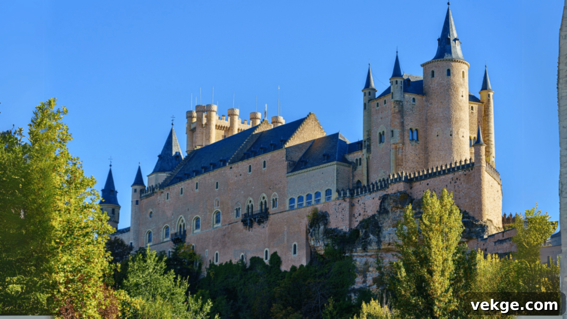The fairytale-like Alcazar of Segovia, a medieval castle perched on a hilltop with distinctive turrets.