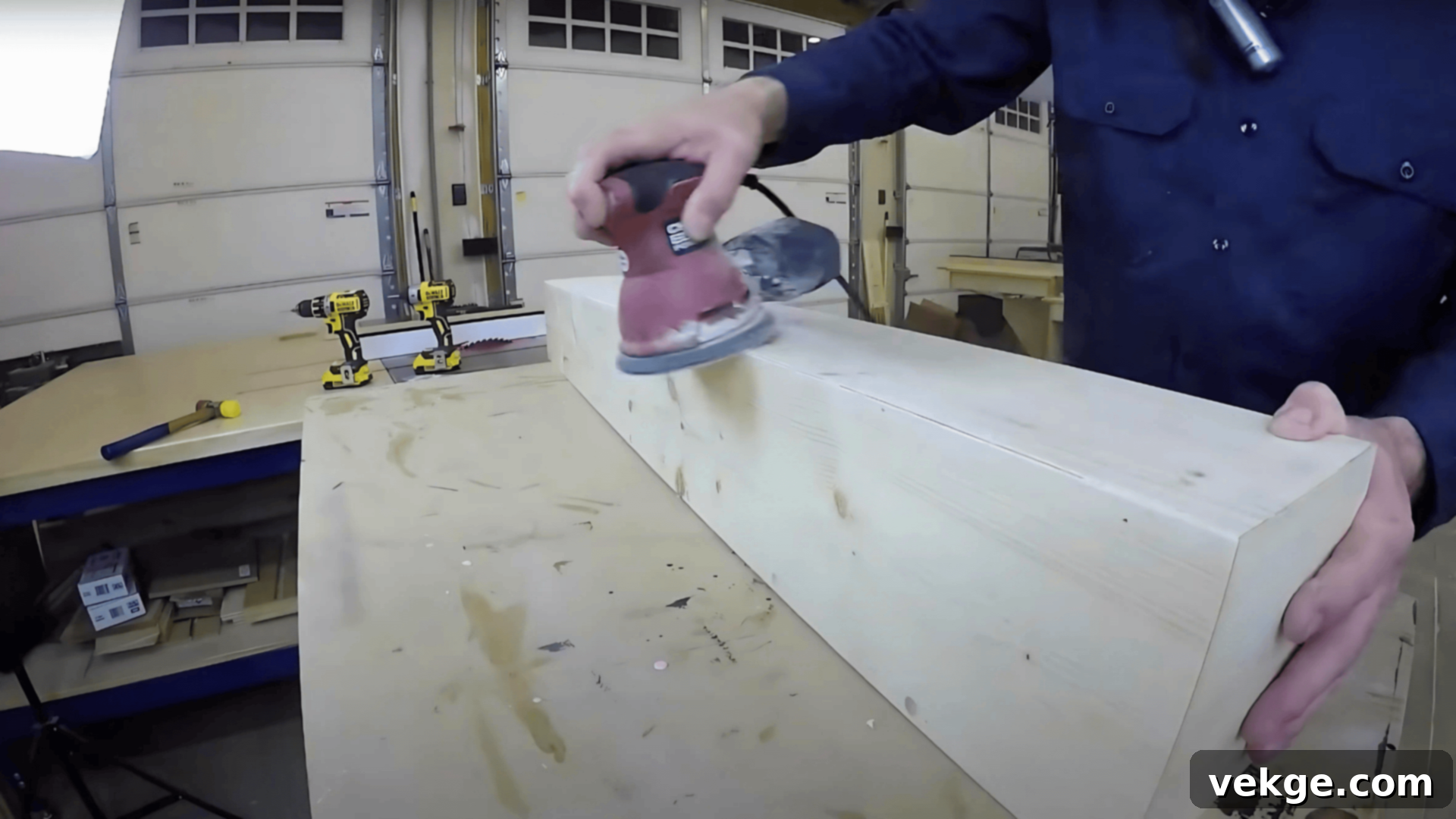 Sanding a faux wood beam smooth to prepare for staining