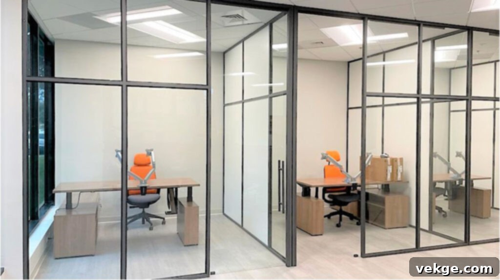 Modern office interior with glass office partitions creating open yet defined workspaces, promoting natural light and collaboration