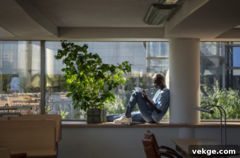 Office space with a large, vibrant artificial green wall, creating a lush, natural ambiance in a modern work environment.