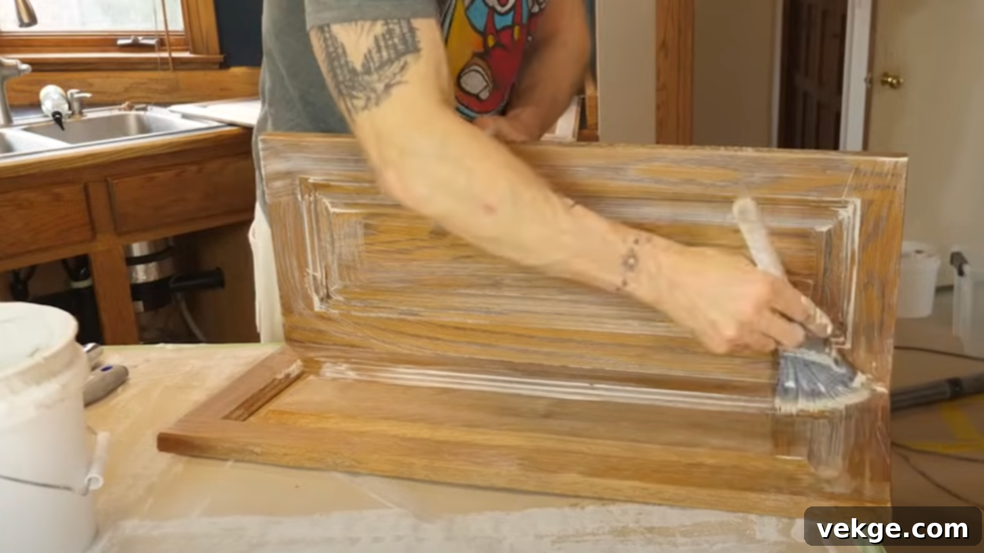 Applying primer to a kitchen cabinet door with a roller for a smooth, even base