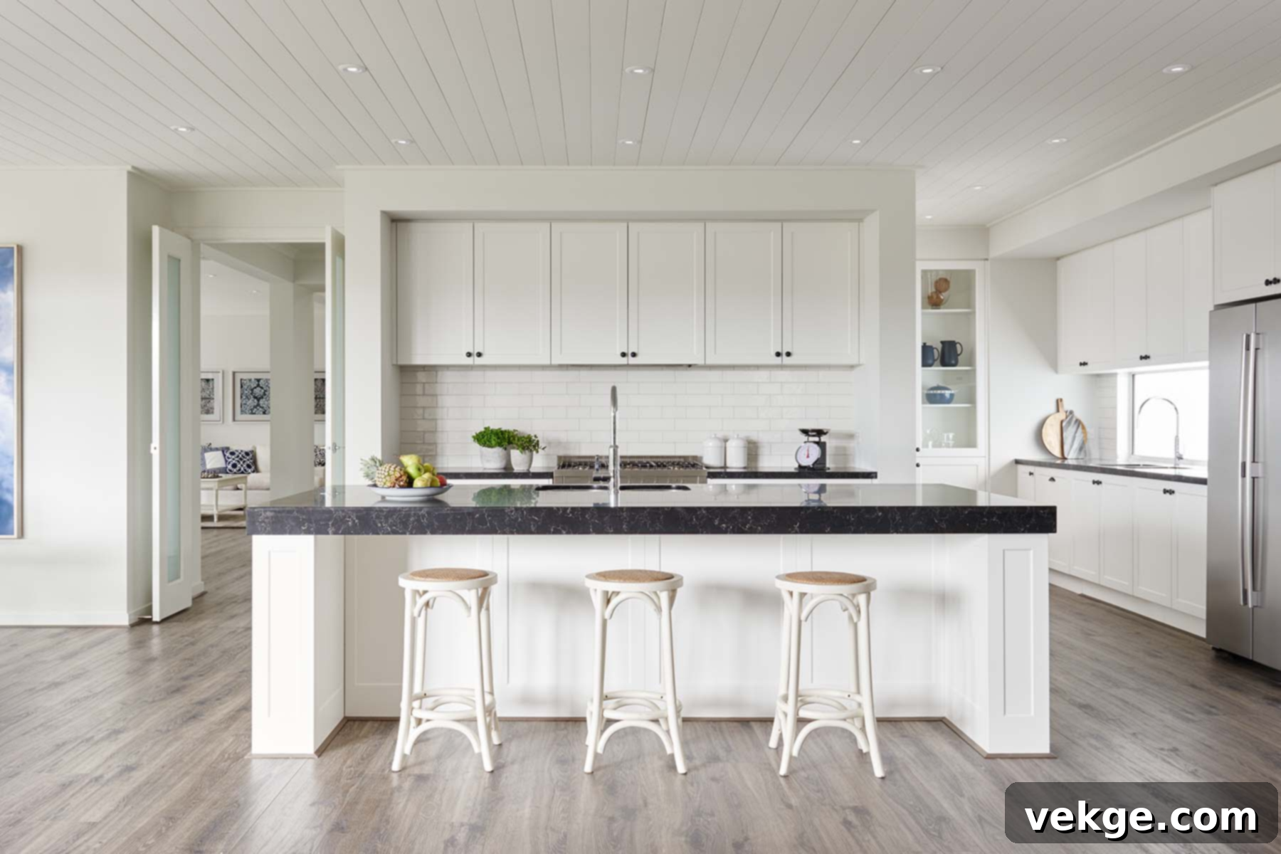 A kitchen with white cabinets and black counter tops and a hybrid flooring
