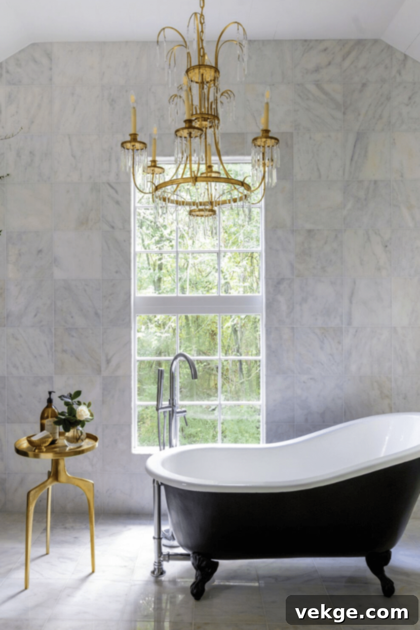 Glamorous chandelier near a large window in a marble-tiled bathroom