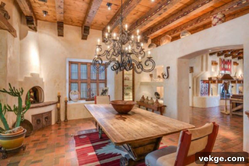 A dining room in Southwestern style featuring a large rustic wooden table, upholstered chairs with tribal patterns, and a prominent display of traditional pottery and copper kitchenware.