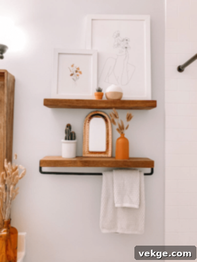 All white bohemian bathroom with natural wood mirror and framed art prints