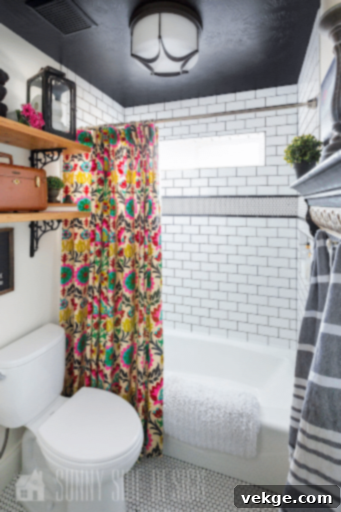 Multilingual bohemian bathroom with dark ceiling, layered art, and varied tiles