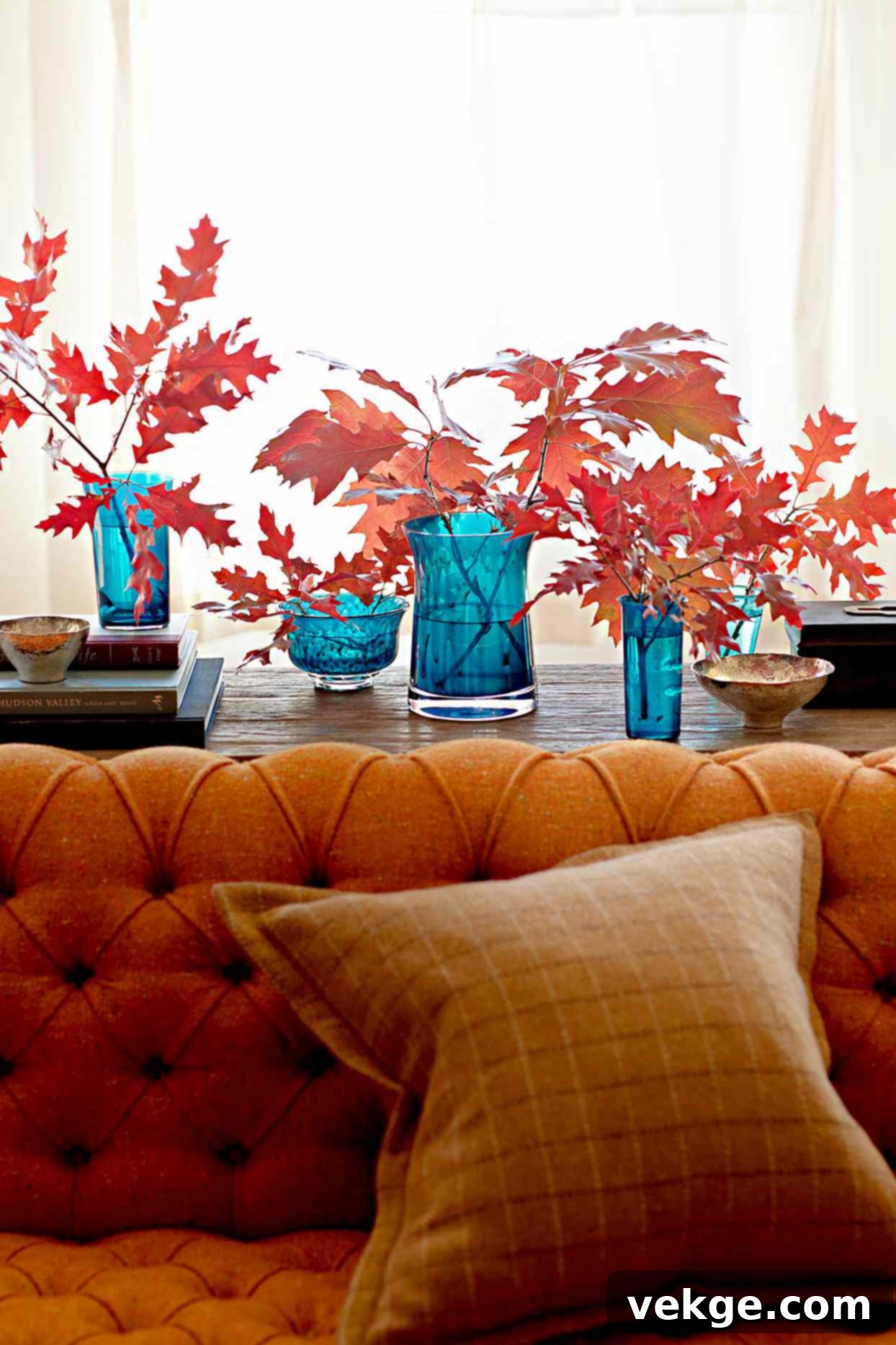 fall leaves in blue glass vases on couch