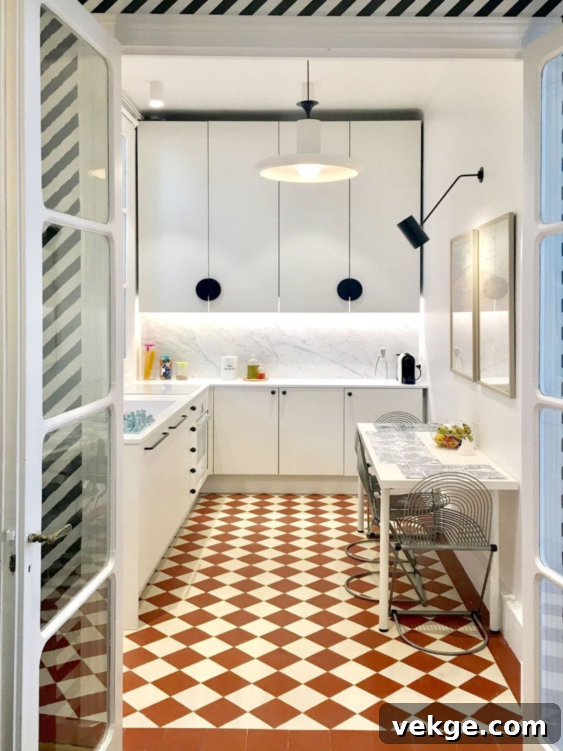 Classic black and white checkered floor in a Parisian kitchen with elegant white cabinetry and a large window.