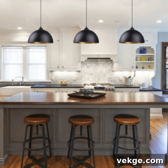 Multiple stylish pendant lights illuminating a kitchen island in a sophisticated Parisian kitchen.