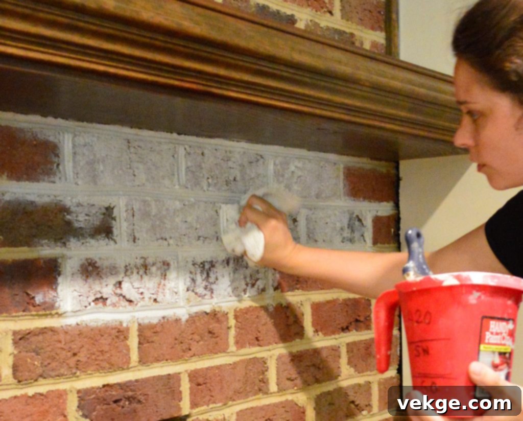 Applying whitewash to brick fireplace with brushes