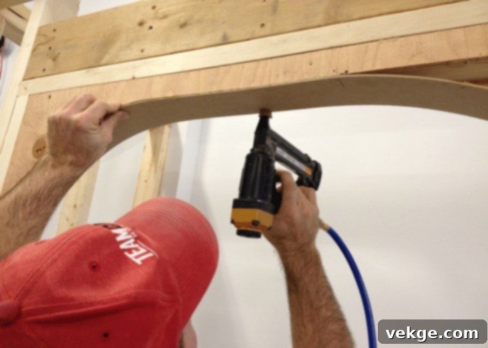 Filling gaps with drywall compound, sanding smooth, and painting the newly installed archway