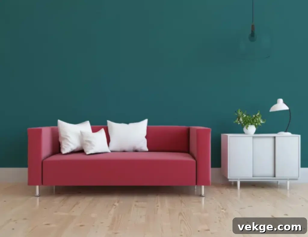 Teal walls providing a unique and calming backdrop for a red sofa, creating a luxurious interior