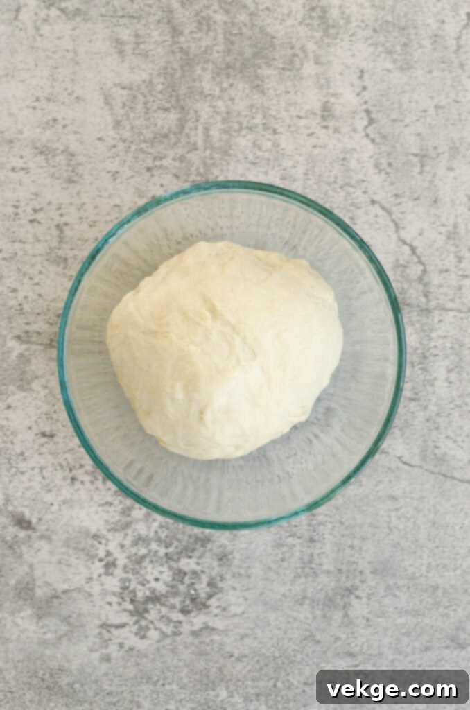 Dough rising in a bowl, covered.