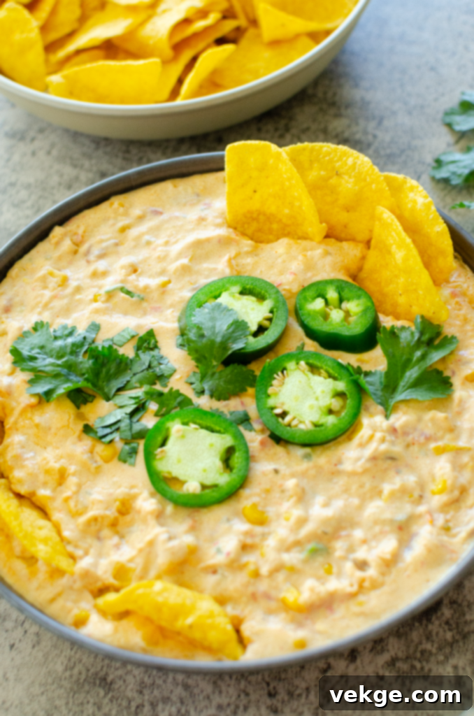Served Creamy Corn Queso Dip in a bowl with tortilla chips