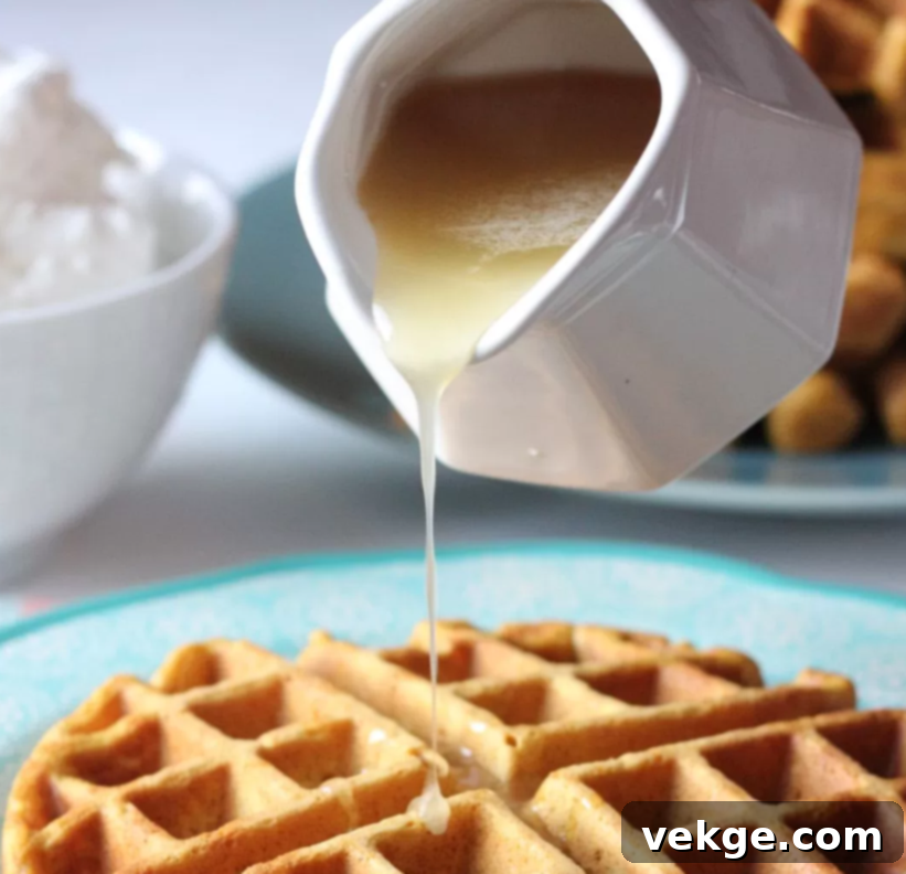 Golden Pumpkin Waffles with Creamy Buttermilk Syrup 4 An appealing overhead view of a perfectly cooked pumpkin waffle with a generous pool of buttermilk syrup.