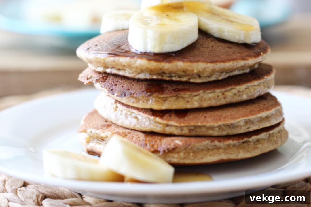 Wholesome Banana Flapjacks 2 Stack of fluffy banana oat pancakes drizzled with syrup, garnished with fresh berries