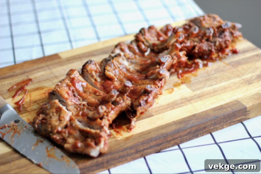 Close-up of raw pork ribs being coated with a savory dry rub.