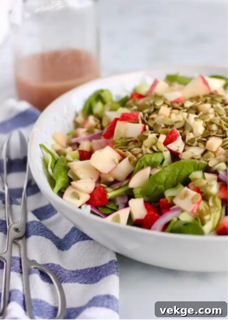The Ultimate Sidekick Salad 2 A vibrant side salad with mixed greens, strawberries, and a creamy dressing, perfect for any meal.