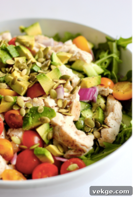 A colorful and appetizing salad with chicken and a creamy dressing.