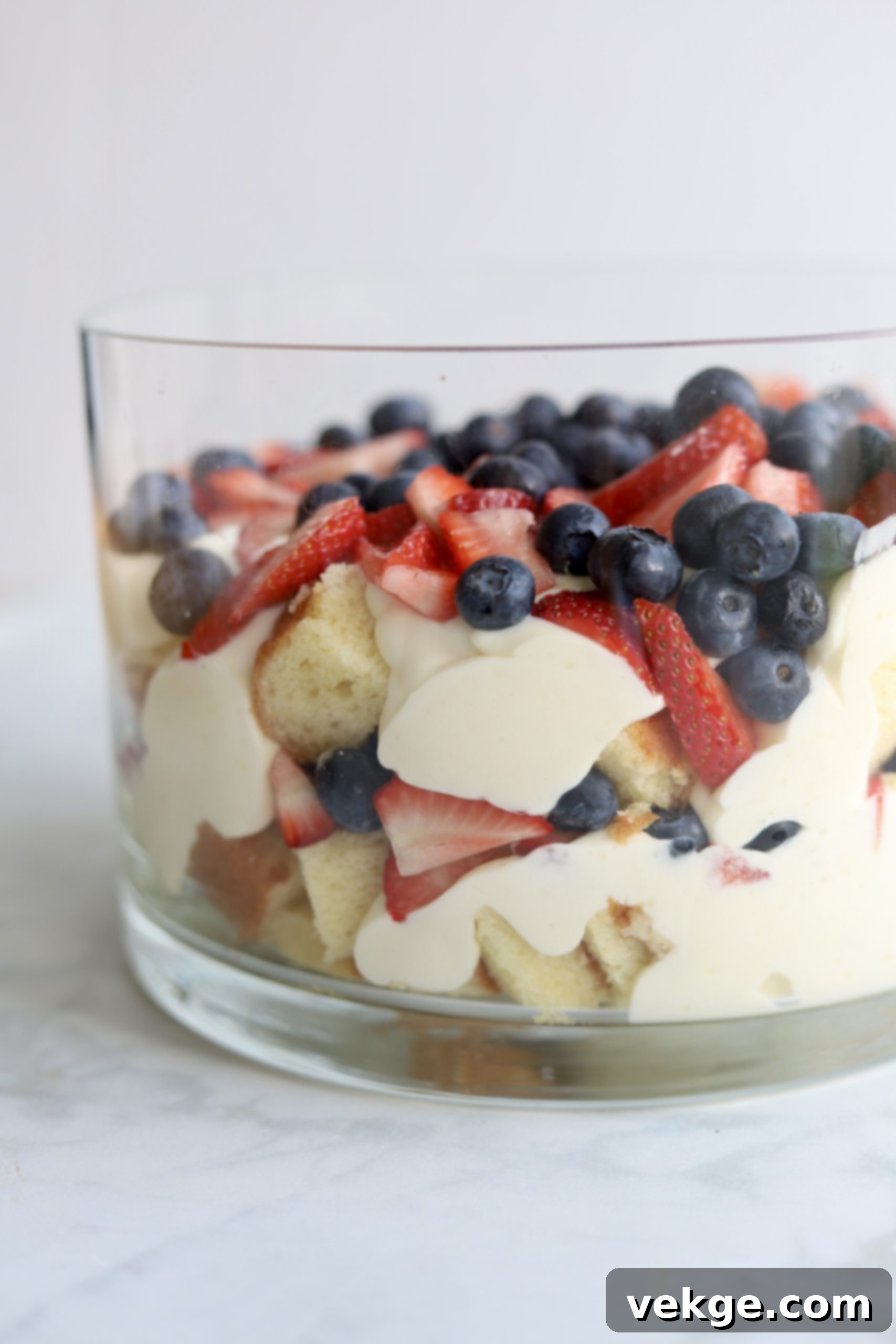 Berry Medley Trifle 2 A stunning berry trifle in a large glass bowl, showcasing layers of cake, pudding, and fresh berries.