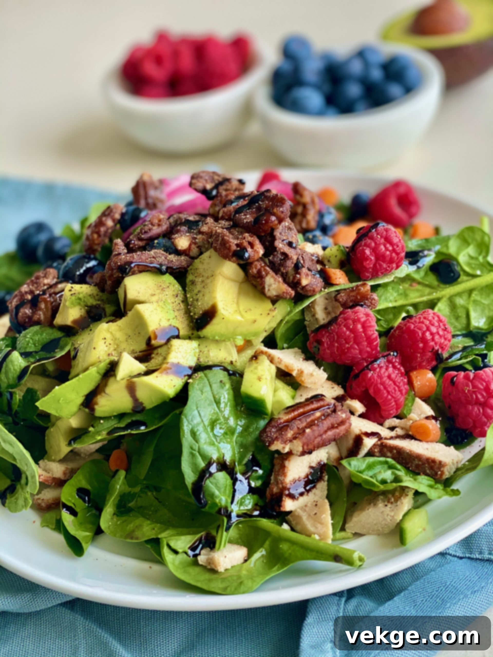 Close-up of fresh spinach and mixed berries, showing the vibrant colors of the salad ingredients.