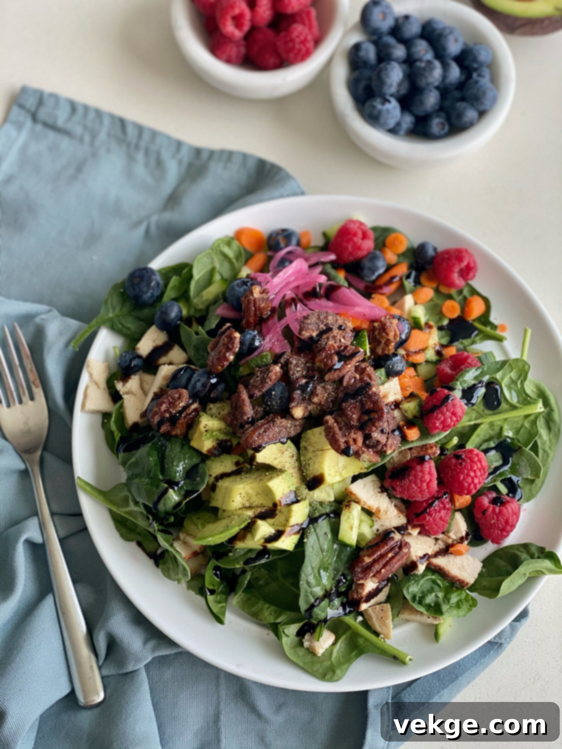 A close-up of the prepared Spinach Berry Salad, showcasing the dressing and fresh ingredients.