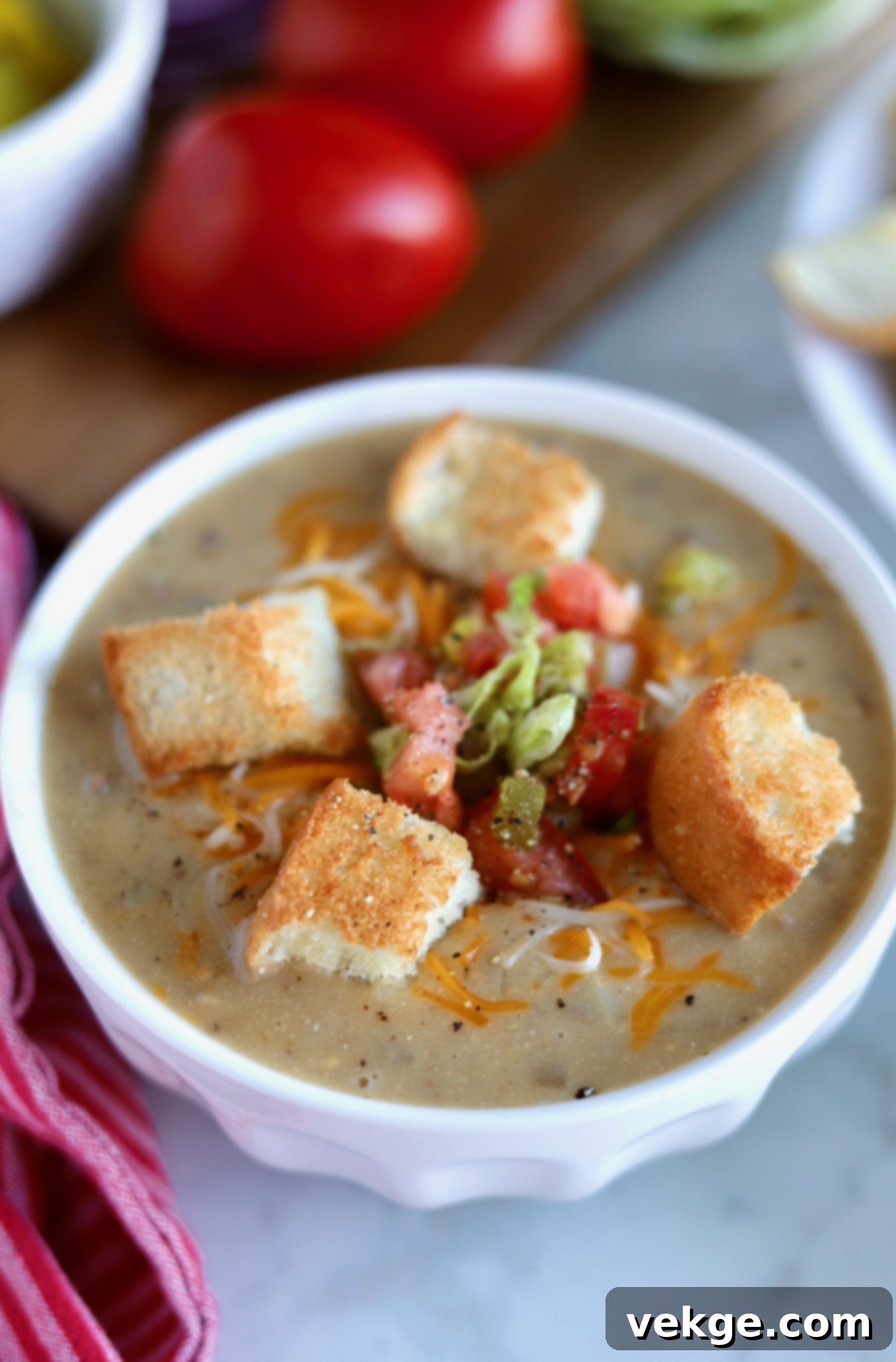 Loaded Cheeseburger Soup 3 Overhead view of a prepared bowl of cheeseburger soup with toppings on the side, showcasing its rich texture and inviting colors.