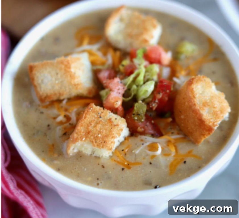 Loaded Cheeseburger Soup 4 A vibrant bowl of cheeseburger soup, garnished with fresh toppings and croutons, presented beautifully.