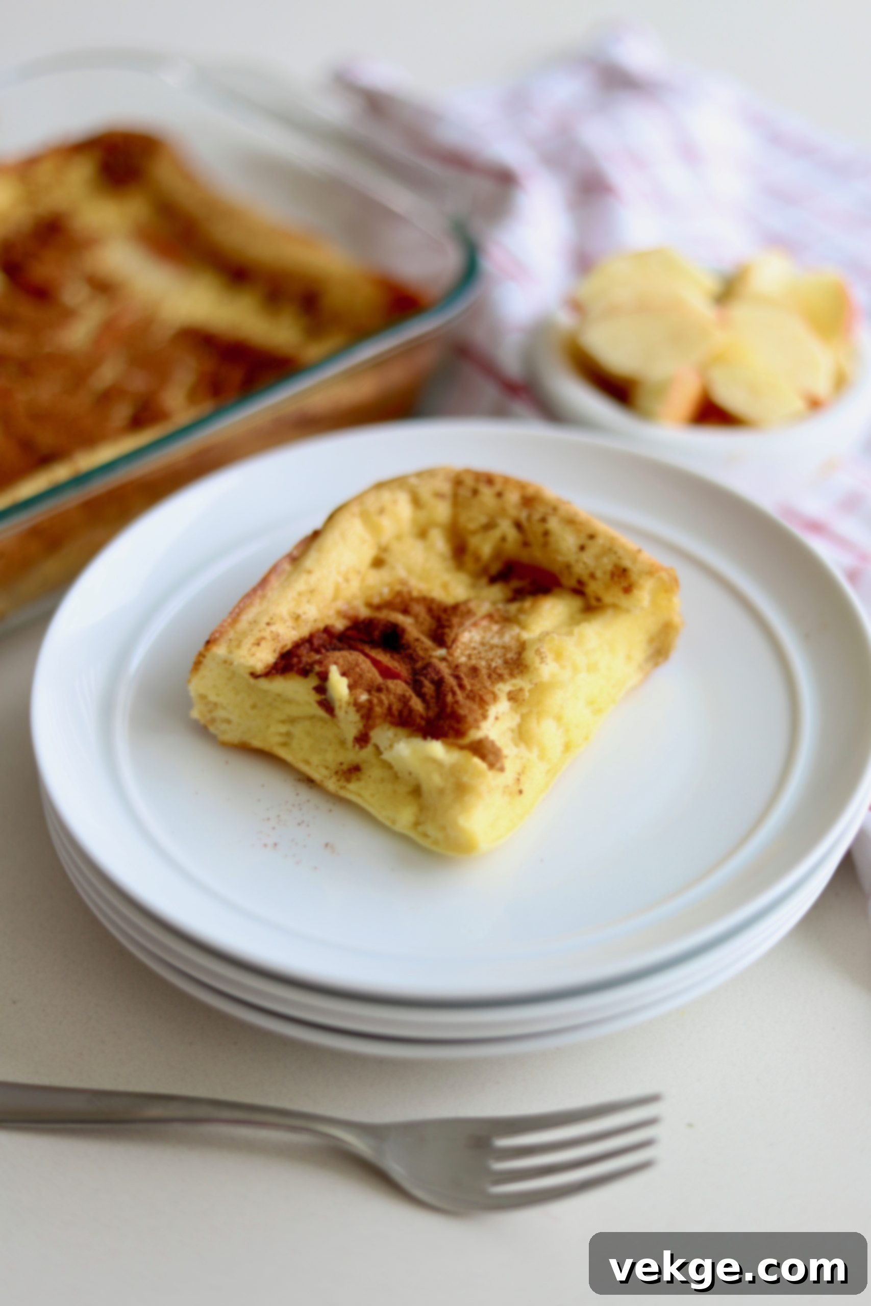 Sourdough German Oven Puff 5 Sourdough German Pancakes in a rectangular baking dish, garnished with powdered sugar and fresh fruit, ready to be served.
