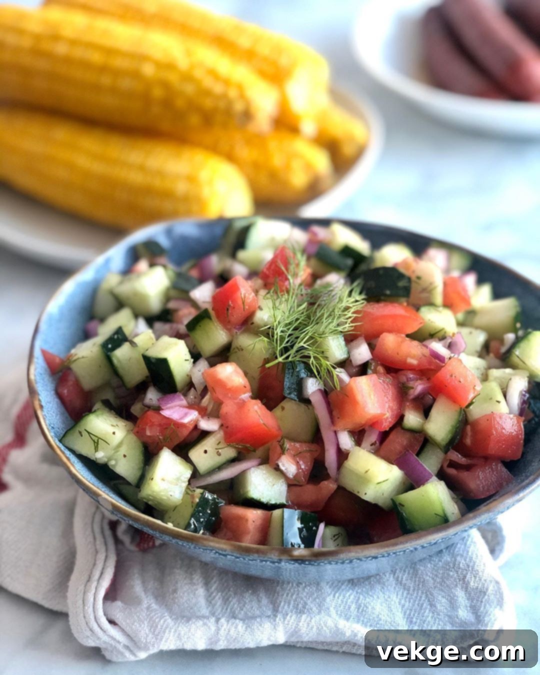 A top-down shot of a bowl filled with fresh cucumber salad, emphasizing the bright colors and the dressing glistening on the vegetables.
