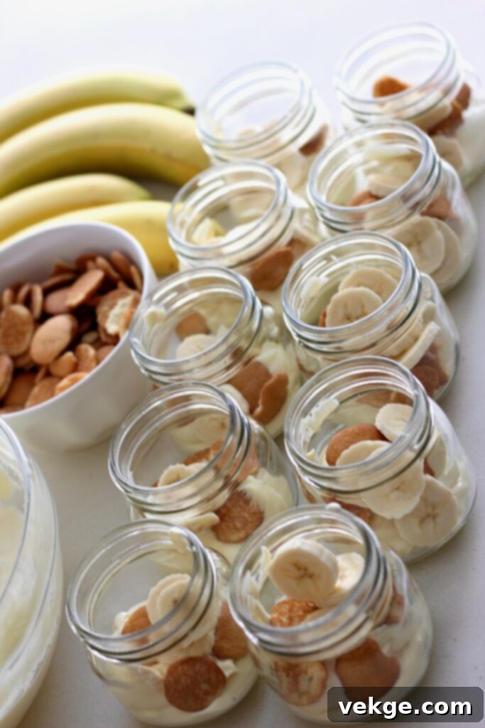 Process photo showing a bowl of banana pudding being mixed with whipped cream