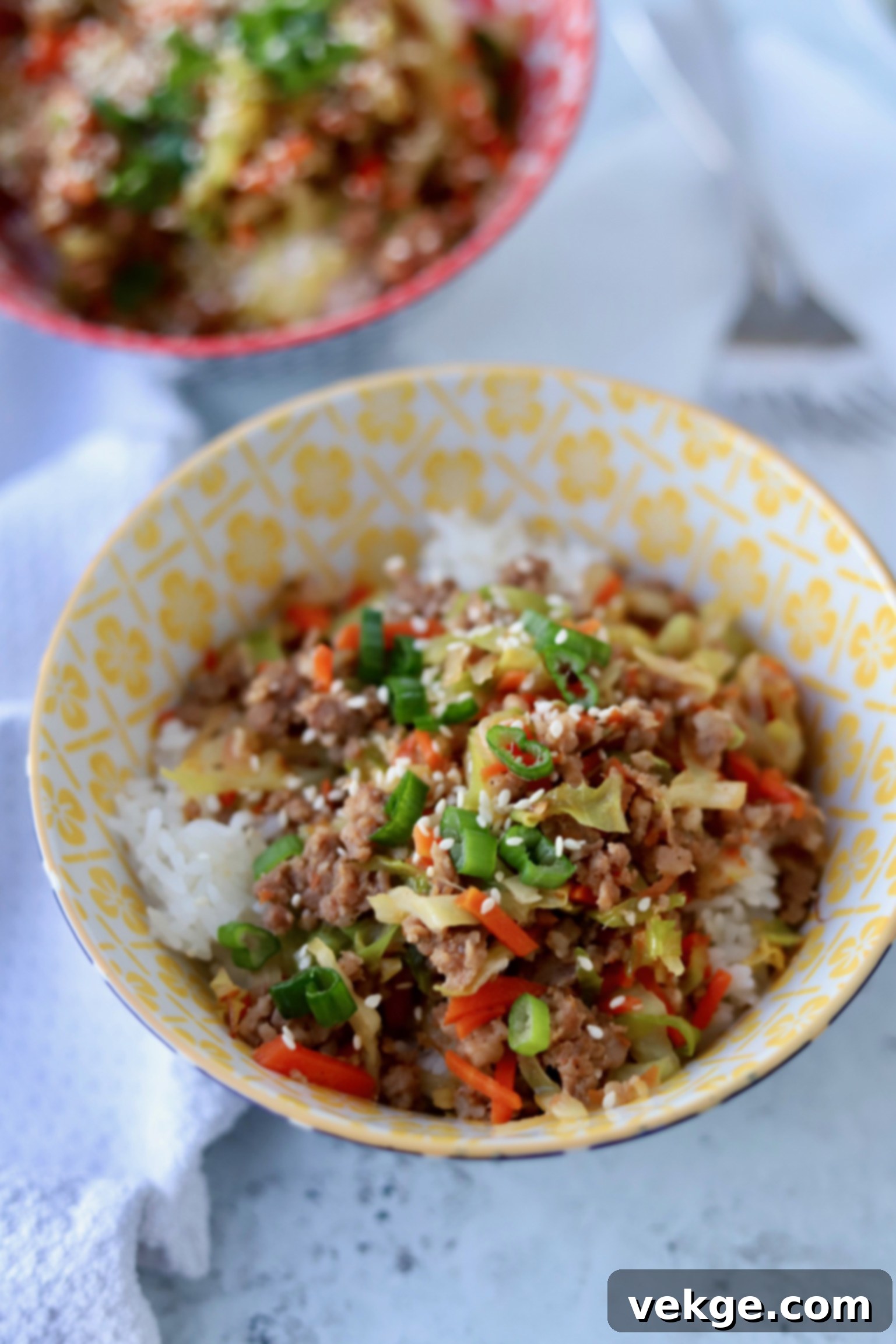 A delicious and hearty Egg Roll in a Bowl, topped with fresh green onions and sesame seeds, ready to be enjoyed.