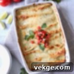 Ultimate Chicken Enchiladas 5 Enchiladas rolled and placed in a baking dish, covered with sauce