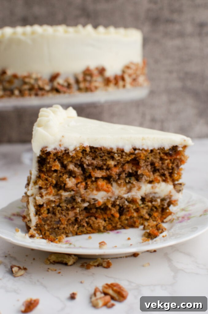 A perfectly baked and frosted carrot cake with a slice removed