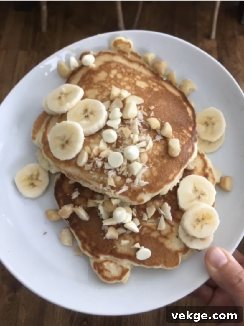 Close-up of golden pancakes on a griddle, with some bubbling.