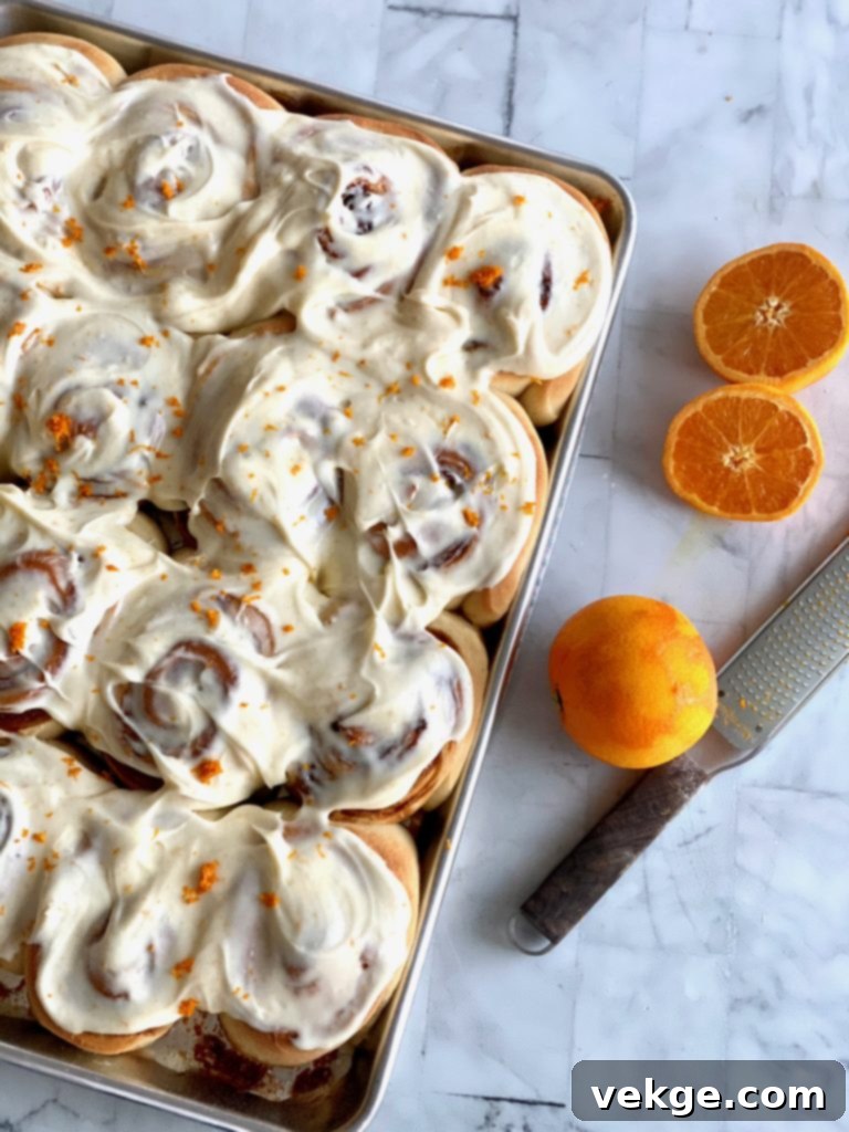 Effortlessly Divine Cinnamon Rolls 22 A close-up of a single, perfectly frosted orange roll, showcasing its soft interior and vibrant glaze.