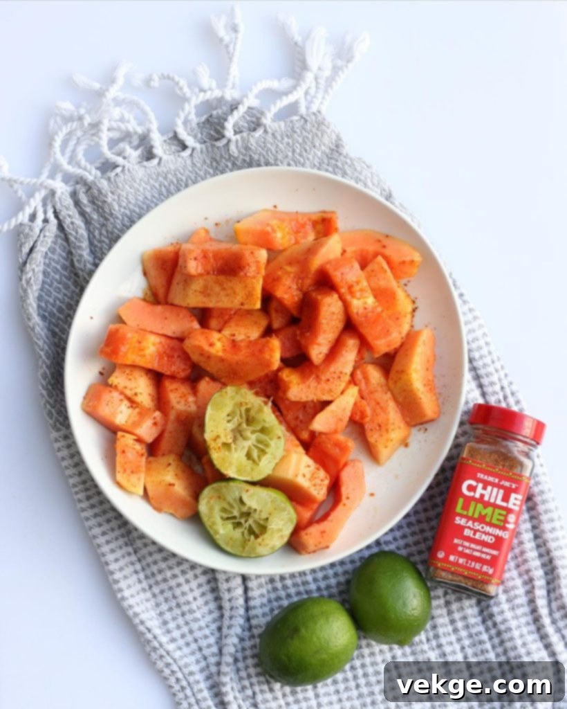 Tropical Papaya Zest 3 Papaya slices garnished with vibrant lime wedges and a generous dusting of chili powder, ready to be enjoyed
