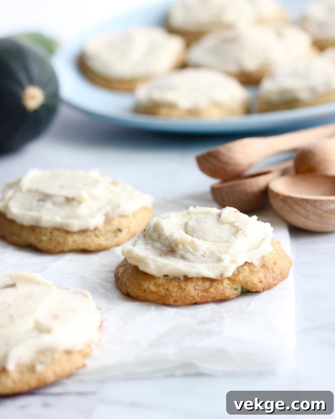 Close-up of a single zucchini cookie with frosting, showing texture and golden flecks