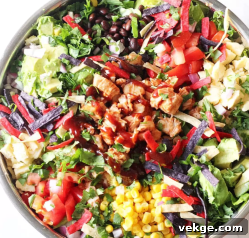 Smoky BBQ Chicken Salad 4 Close-up of a vibrant BBQ Chicken Salad in a bowl, topped with tortilla strips and cilantro.