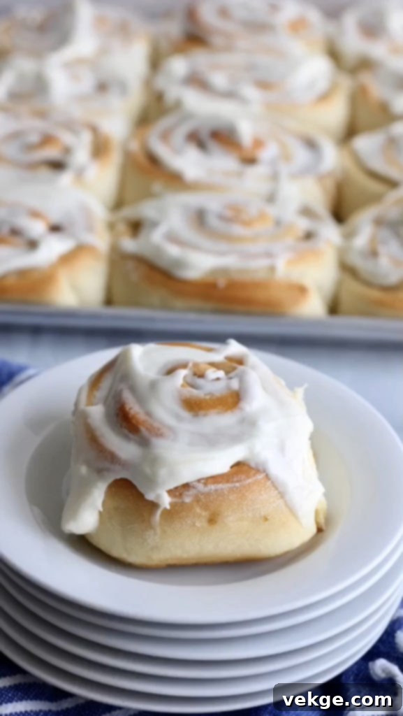 Freshly baked sourdough cinnamon rolls, glistening with frosting, ready to be enjoyed.