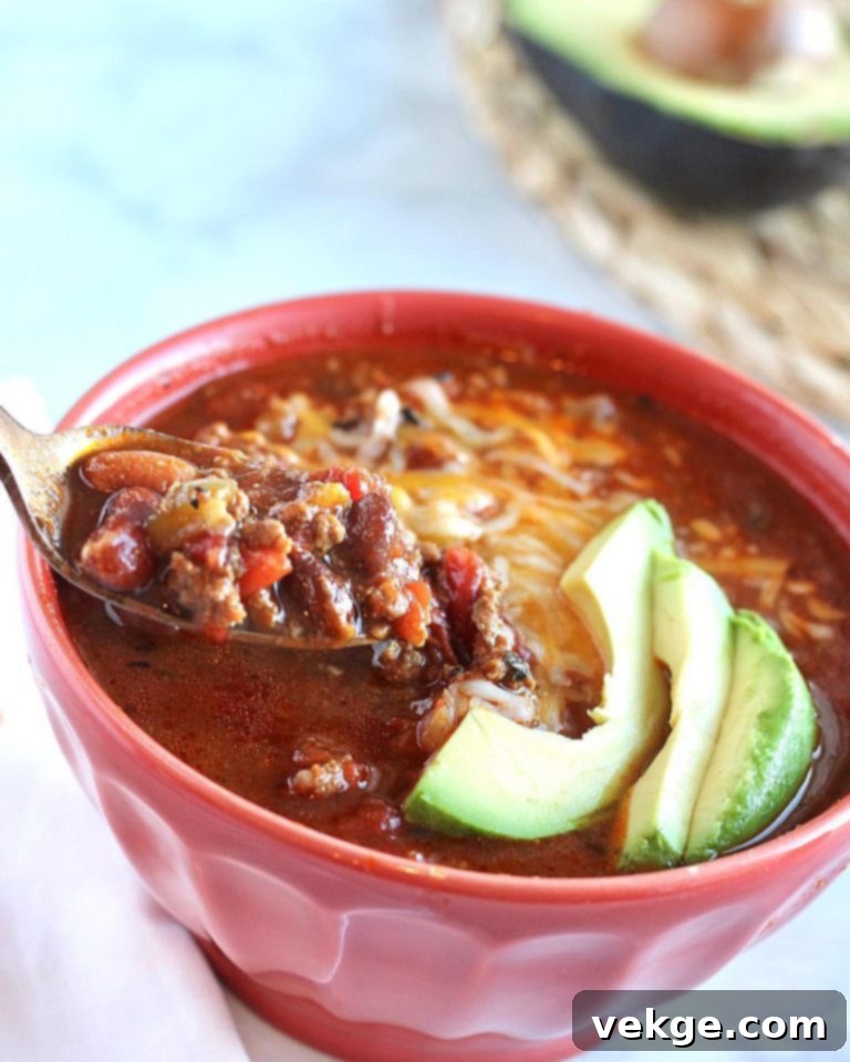 Close-up of simmering chili in a pot, rich in beans and meat.
