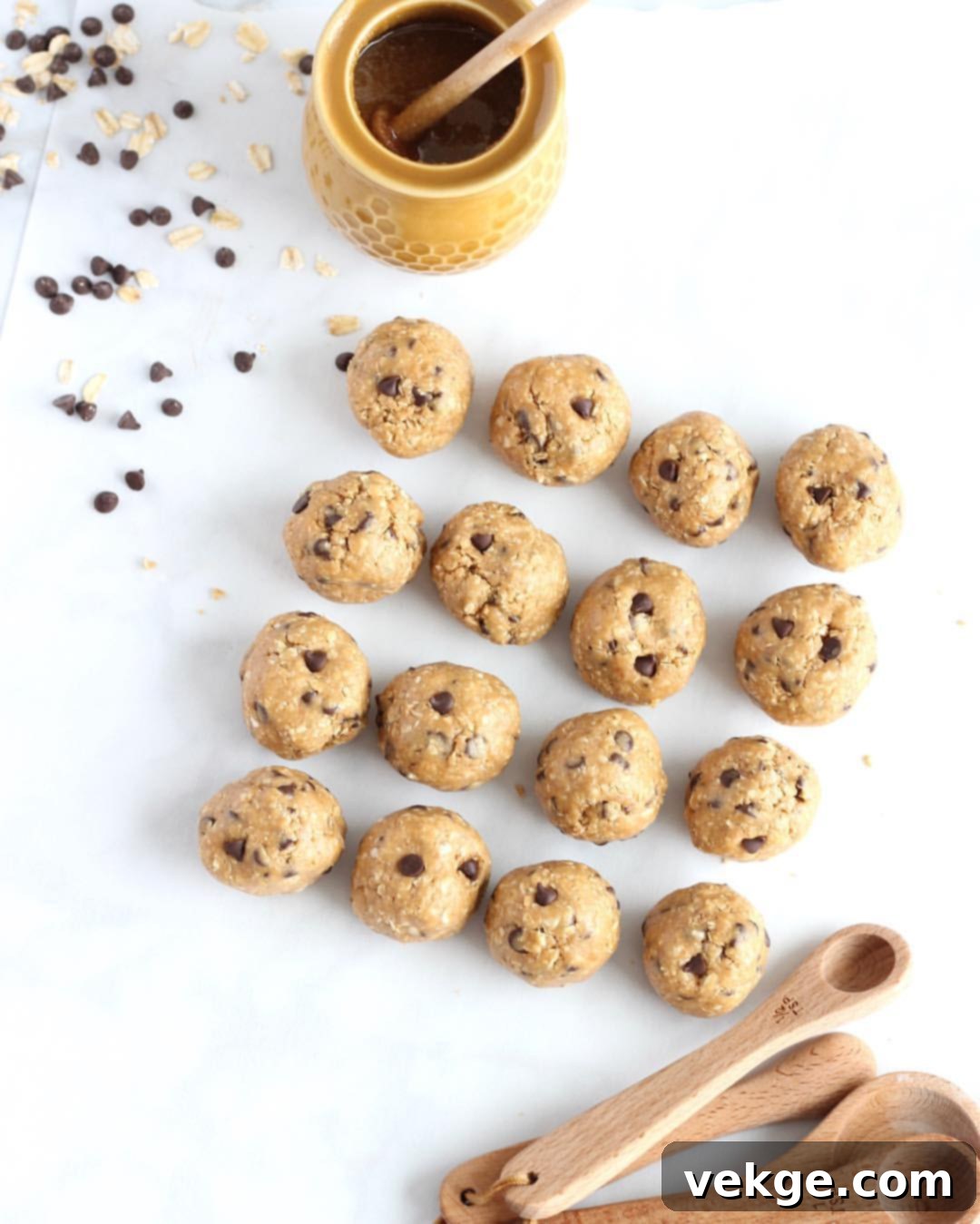 A generous pile of Peanut Butter Chocolate Chip Cookie Dough Balls arranged on a rustic wooden board, ready for snacking.