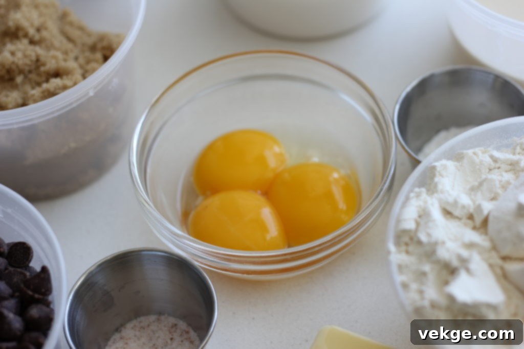 A bowl of egg yolks and a jar of vanilla extract.
