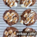 Gooey Smores Chocolate Chunk Cookies 9 A hand reaching for a warm S'mores cookie, still gooey from the oven.