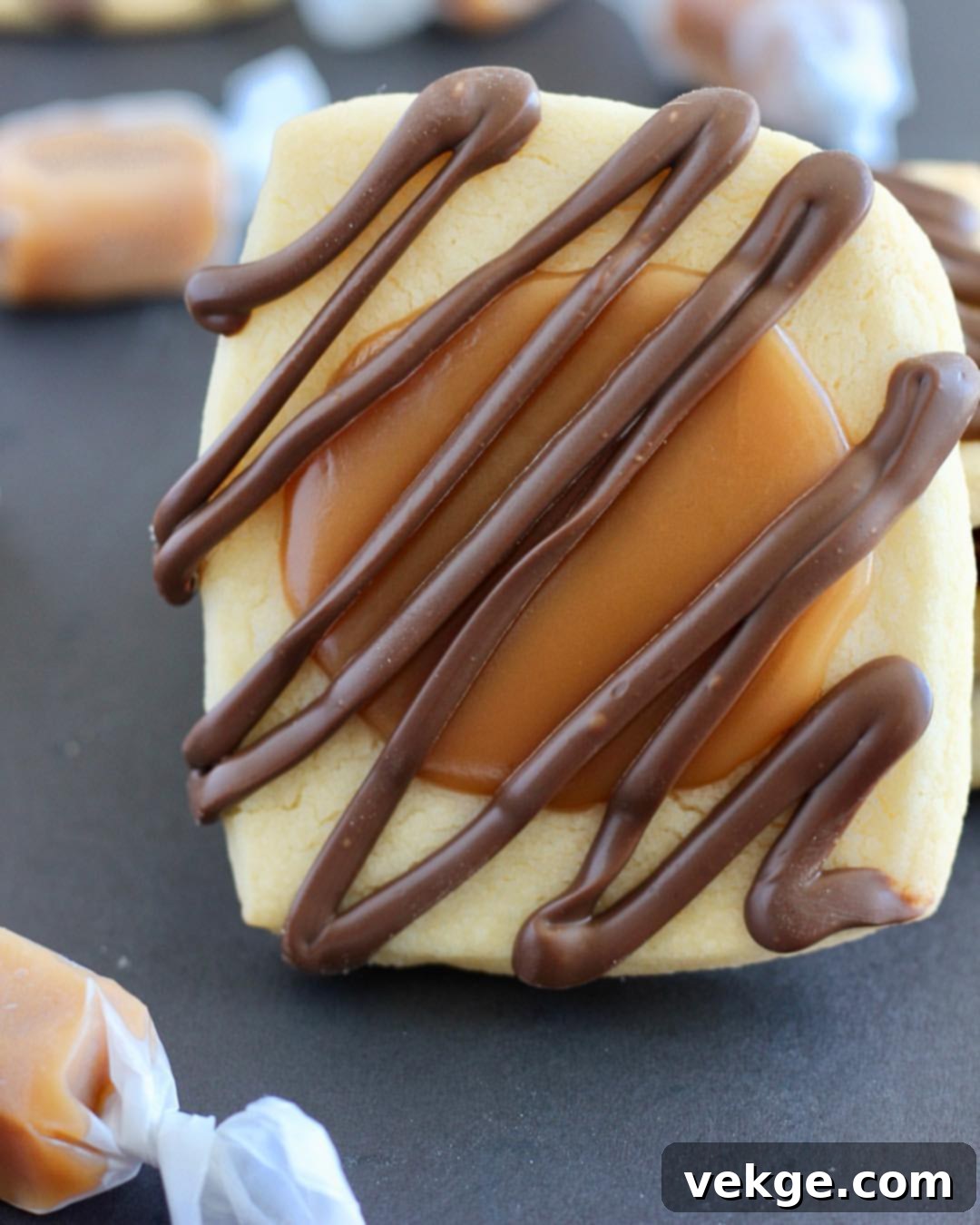 Ultimate Twix Cookie Delight 3 Close-up view of two homemade Twix Cookies, showcasing the layers of shortbread, caramel, and chocolate drizzle.