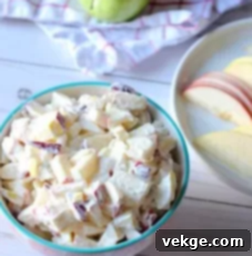 A beautifully presented, chilled bowl of creamy apple salad, garnished and ready to serve.