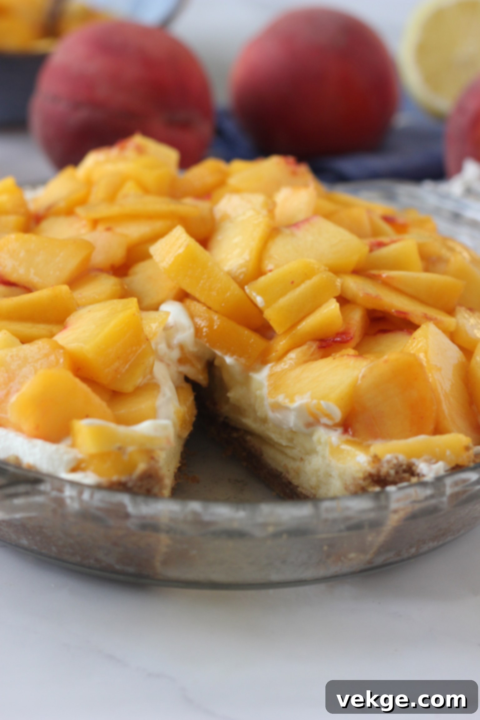 Velvet Peach Cloud Pie 4 Up close picture of Heavenly Fresh Peach Cream Pie with a slice taken our of it.